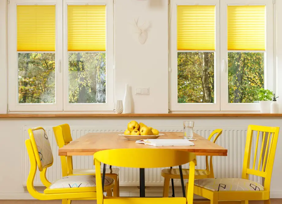 Yellow pleated blinds in a dining room