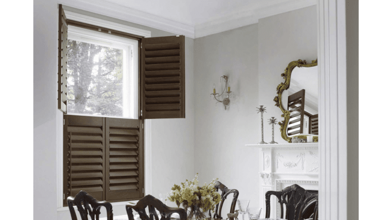 Dark wood tier on tier shutters in a dining room