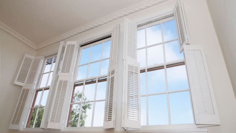 White tier on tier shutters open to show blue sky outside